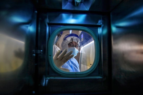 Image: A medical staff member gestures inside an isolation ward at Red Cross Hospital in Wuhan in China's central Hubei province