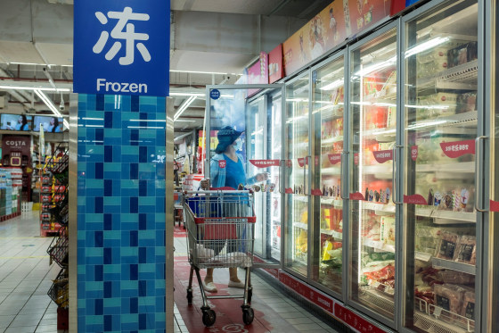 Image: A woman looks at frozen food products in a supermarket in Beijing
