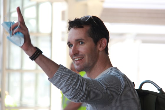 Image: Australian Broadcasting Corporation journalist Bill Birtles waving as he arrives in Sydney after leaving China over arrest fears, amid worsening diplomatic relations between the two countries