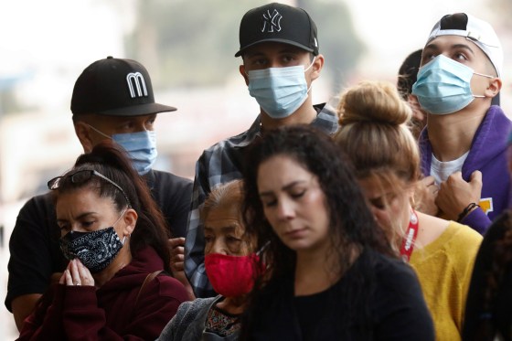 Image: People pray during a prayer vigil following the ambush shooting of two Los Angeles County Sheriffs Department (LASD) deputies in Compton, outside St. Francis Medical Center hospital in Lynwood