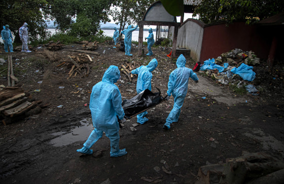 Image: Health workers wearing personal protective equipment carry the body of a COVID-19 victim for cremation in Gauhati, India,