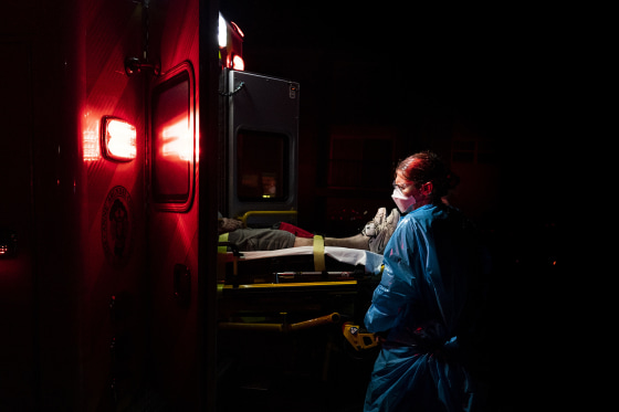 A paramedic places a patient with Covid-19 symptoms inside an ambulance in Brooklyn Park, Md.