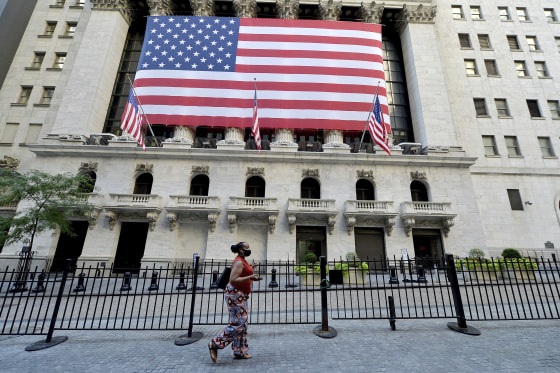 A woman wearing a face masks walks past a large American flag on the facade of the New York Stock Exchange in New York, NY, September 8, 2020. Stocks closed lower as the DOW dropped 630 points due in part to fears of a COVID-19 resurgence and the economic effect it could have on the economy. (Anthony Behar/Sipa USA)(Sipa via AP Images)