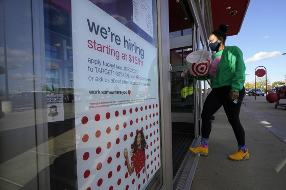 Image: A passerby walks past a hiring sign while entering a Target store in Westwood, Mass. Sept. 30, 2020.