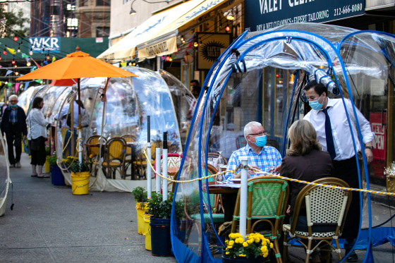Image: People sit outside Cafe Du Soliel under bubble tents