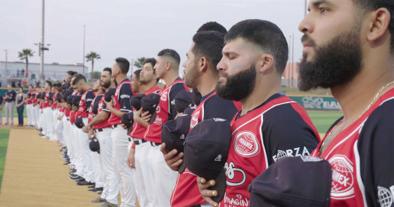 Members of the Tecolotes de los Dos Laredo, a binational professional baseball team with home stadiums in Nuevo Laredo, Mexico, and Laredo, Texas, stand for the U.S. National Anthem in a scene from the Showtime documentary "Bad Hombres."
