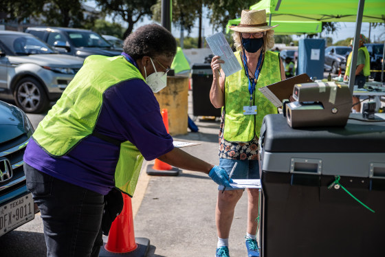 Image: Workers drop voters ballots into a secure box at a ballot drop off location on Oct. 13, 2020 in Austin, Texas.