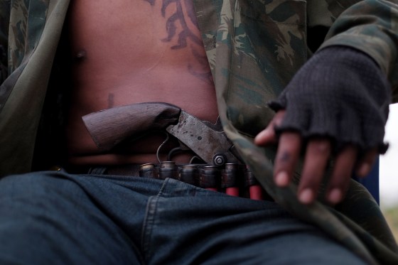 Image: Guardian of the Forest Paulo Paulino Guajajara, 22, wears a pistol while hanging out a a school house that serves as a base in Arariboia Indigenous Reserve, Maranhao, Brazil.
