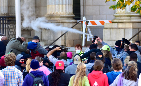Image: Law enforcement officers spray protesters shortly after a moment of silence during a Get Out The Vote march in Graham