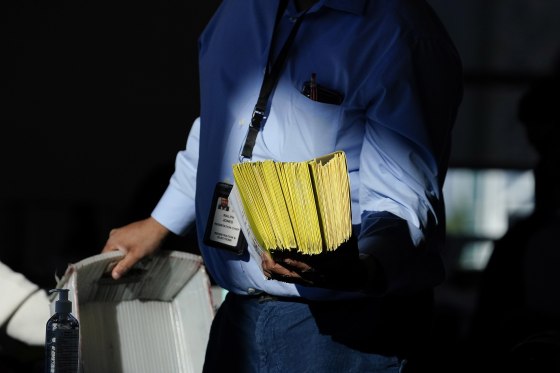 Image: An election worker distributes ballots as vote counting in the general election continues at State Farm Arena on Thursday, Nov. 5, 2020, in Atlanta.