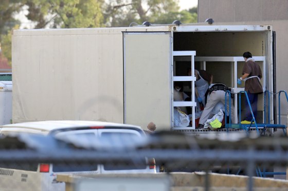 Image: Refrigerated trailers are seen parked at the rear of the El Paso County Office of the Medical Examiner in El Paso