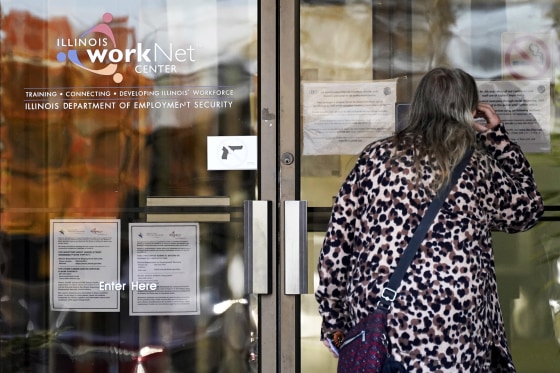 Image: A woman checks information as information signs are displayed at IDES (Illinois Department of Employment Security) WorkNet center in Arlington Heights, Ill
