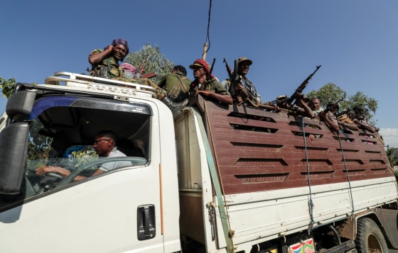 Image: FILE PHOTO: Members of Amhara region militias ride on their truck as they head to face the Tigray People's Liberation Front in Sanja