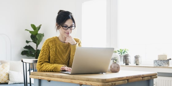 Image: Woman sitting at table, using laptop