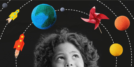 Image: A child looks up at planets made of thermocol, paper rockets and windmills orbiting around his head