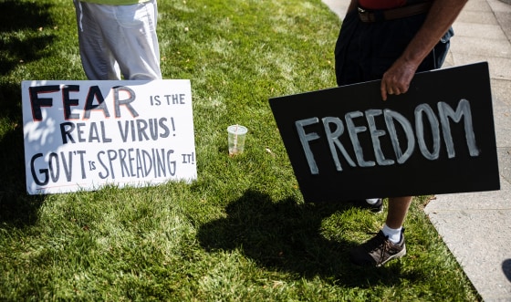 Image: Protesters hold placards during an 'Anti-Mask' rally at Ohio