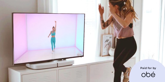 Woman working out to an Ob? fitness class in her home