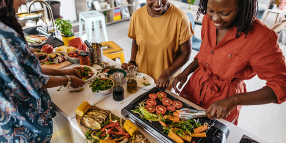 Illustration of a family using an indoor grill in their kitchen to cook food