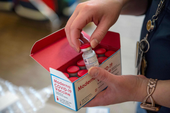 Image: A person unpacks a special refrigerated box of Moderna Covid-19 at the East Boston Neighborhood Health Center.