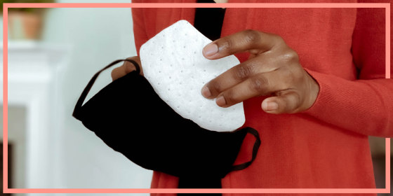 Woman replacing a face mask filter in her cloth facemask