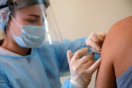Image: A person receives an injection with Sputnik V vaccine in the village of Donskoye in Stavropol Region, Russia