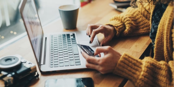 Woman in cafe shopping online with laptop