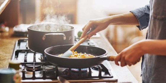 Woman cooking on her stovetop with her new cookware set