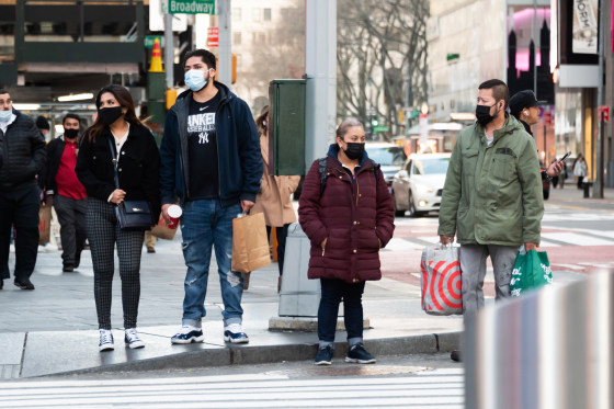 People carry shopping bags in Times Square on March 09, 2021, in New York.