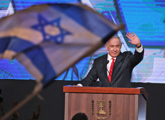 Image: Israeli Prime Minister Benjamin Netanyahu, leader of the Likud party, waves to supporters at the party campaign headquarters in Jerusalem