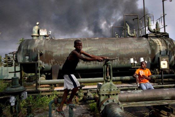 Image: Children play on an abandoned oil flow station near smoke from a burning oil pipe in Kegbara Dere, Nigeria, in 2007.