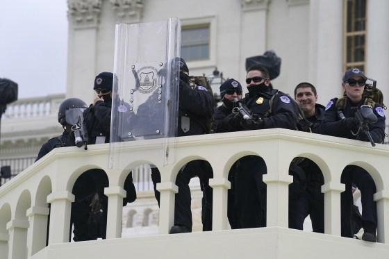 Image: U.S. Capitol Police officer stand as violent rioters storm the Capitol, in Washington