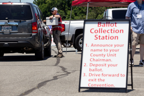 Volunteers hand out and collect ballots from delegates via drive-through lanes during the convention at Tree of Life Ministries in Lynchburg, Va., on June 13, 2020.