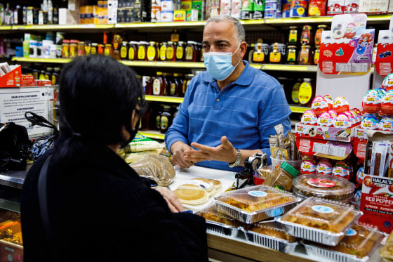 Hamed Nabawy Hamed explains to a customer how to prepare a dish at his halal grocery store Fertile Crescent in Brooklyn, N.Y., on May 5, 2021.
