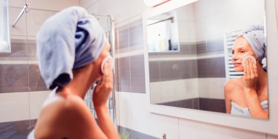Woman cleaning her skin in bathroom