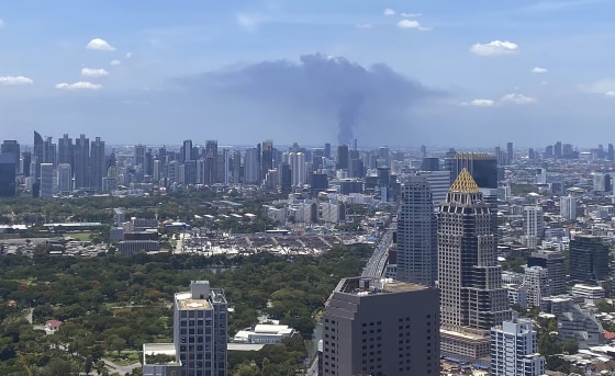 Image: In a view from downtown Bangkok, giant plumes of smoke can be seen rising from the Samut Prakan province area in central Thailand,