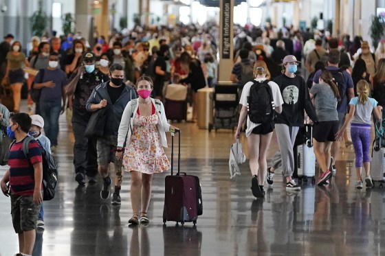 Image: Travelers walk through Salt Lake City International Airport in Salt Lake City on July 1, 2021.