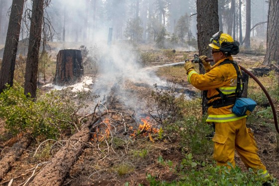 A firefighter out of California puts out hot spots on the Bootleg Fire north of Bly, Ore., on July 17, 2021.