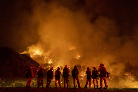 September 9: A group of inmate firefighter watch as the El Dorado Fire burns a hillside near homes in Mountain Home Village, California, inside the San Bernardino National Forest, September 9, 2020.