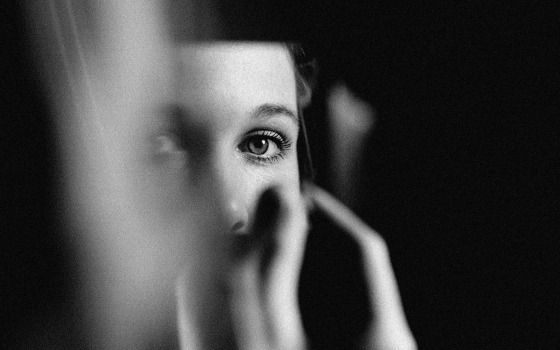 Image of a woman's eyes in a sliver of mirror.