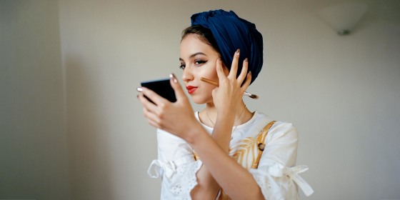 Portrait of young muslim woman applying make up