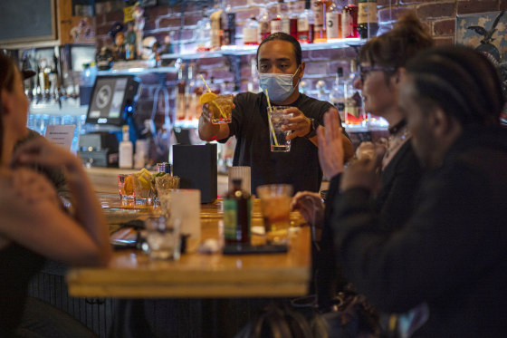 Image: A bartender serves drinks in a bar in San Francisco on May 6, 2021.