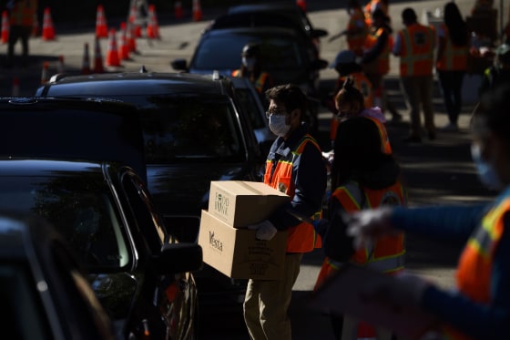 Image: Workers load boxes of groceries into vehicles at a mobile food distribution in Los Angeles on Feb. 5, 2021.