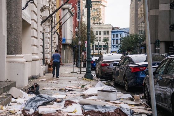 Image: A person walks past debris on the sidewalk after Hurricane Ida passed through on August 30, 2021 in New Orleans.