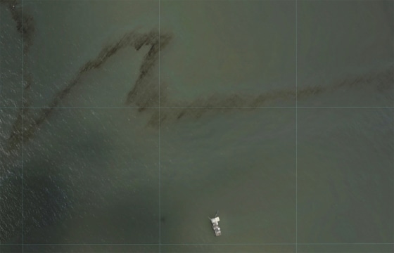 Image: A dark trail appears on the waters of the Gulf of Mexico near an oil industry platform