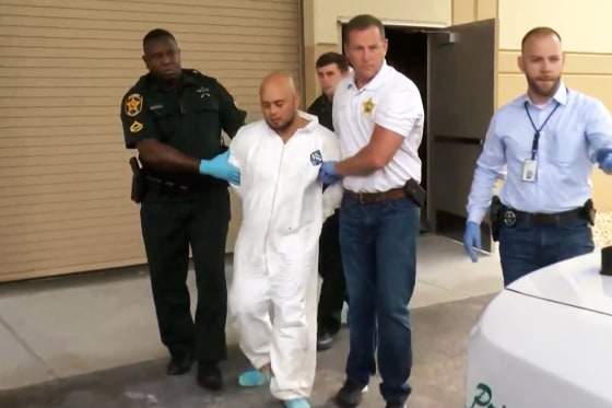 Police escort murder suspect Bryan Riley toward a police vehicle in Lakeland, Fla., on Sept. 5, 2021.