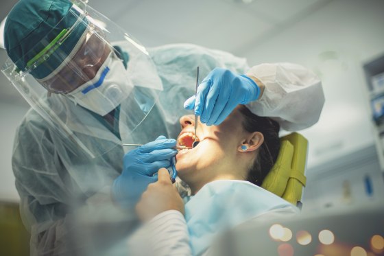 A dentist performs a procedure.
