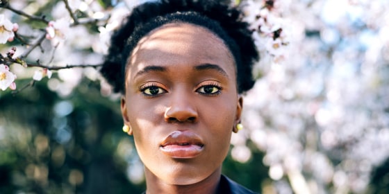 Young Woman against blossom spring trees outdoors