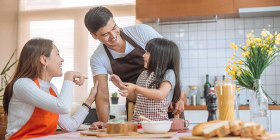Family preparing to bake in a kitchen wearing aprons