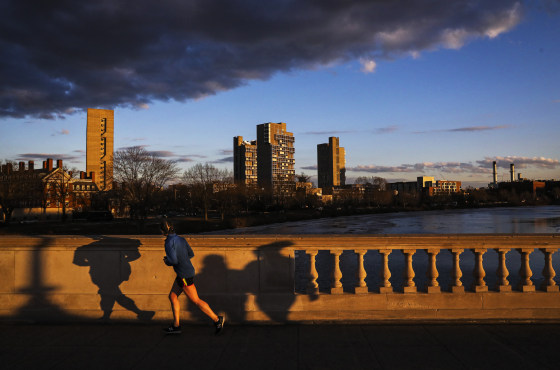Pedestrians walk across the John W. Weeks Footbridge in Cambridge, Mass., on Feb. 10, 2022.