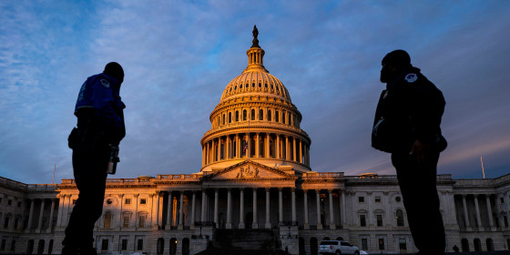 Image: Capitol Police Officers stand on the East Plaza of the Capitol Campus as the dome of the U.S. Capitol Building is illuminated by the rising sun on Capitol Hill.